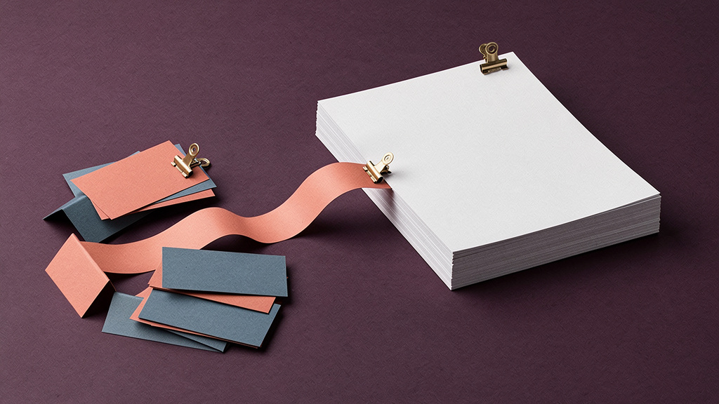 Blank clinical records and patient comment slips joined by a paper ribbon on a plum field.